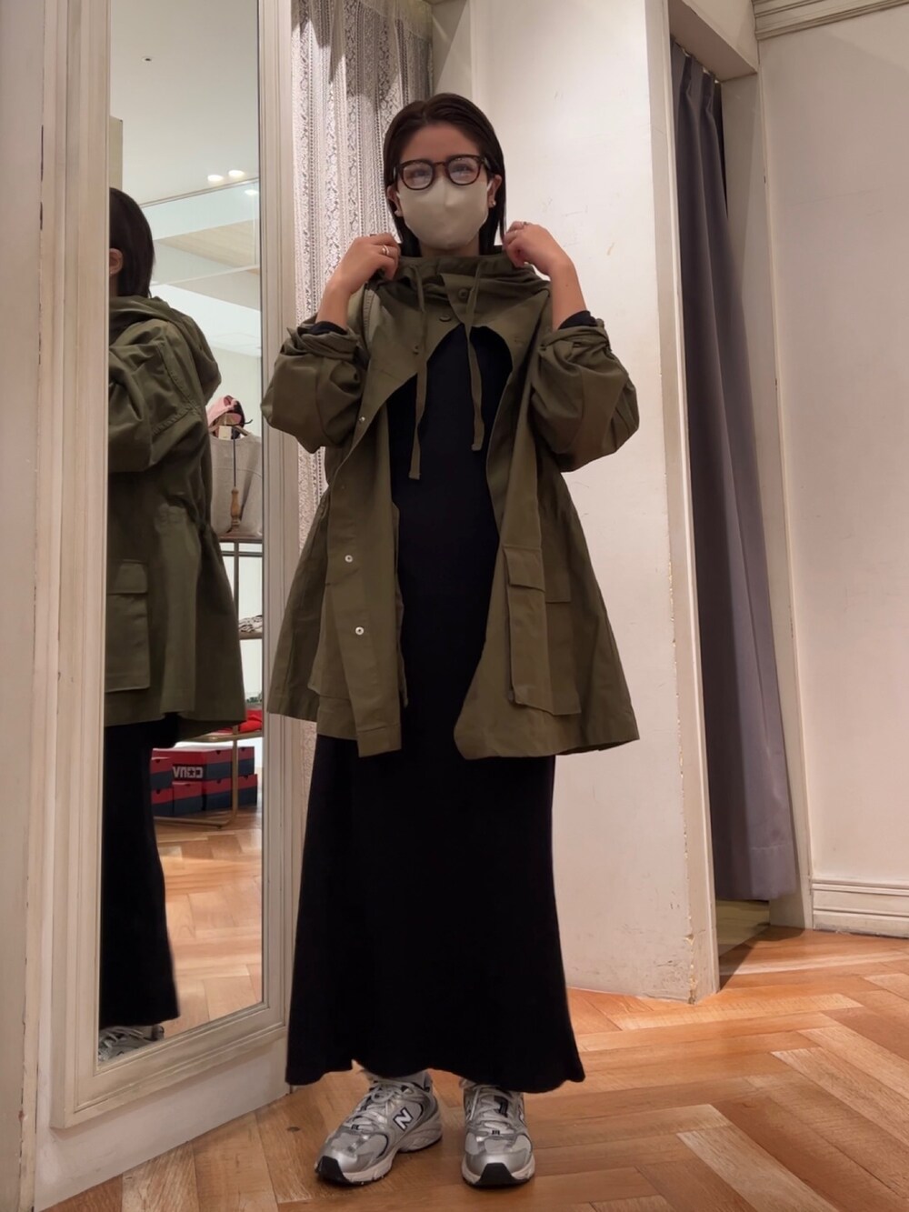 ブラック系のワンピース、グリーン系のブルゾン、ブラウン系のメガネを着用したレディースの冬コーディネートの2枚目の写真