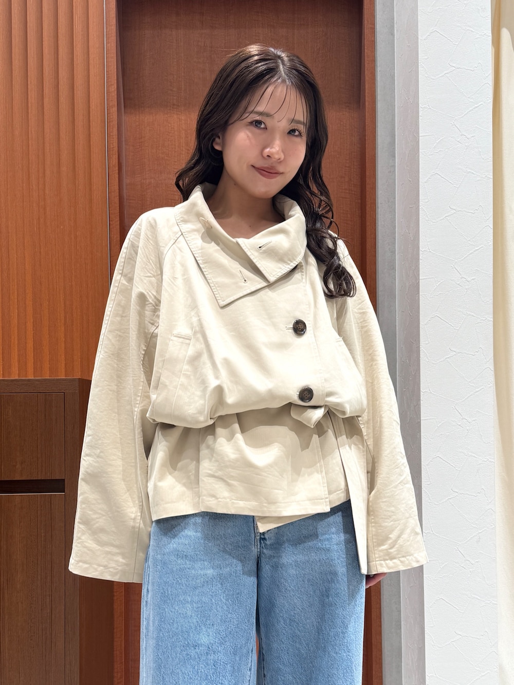 ベージュ系のトレンチコート、ブルー系のデニムパンツ、ブラック系のサンダルを着用したレディースの秋コーディネートの7枚目の写真
