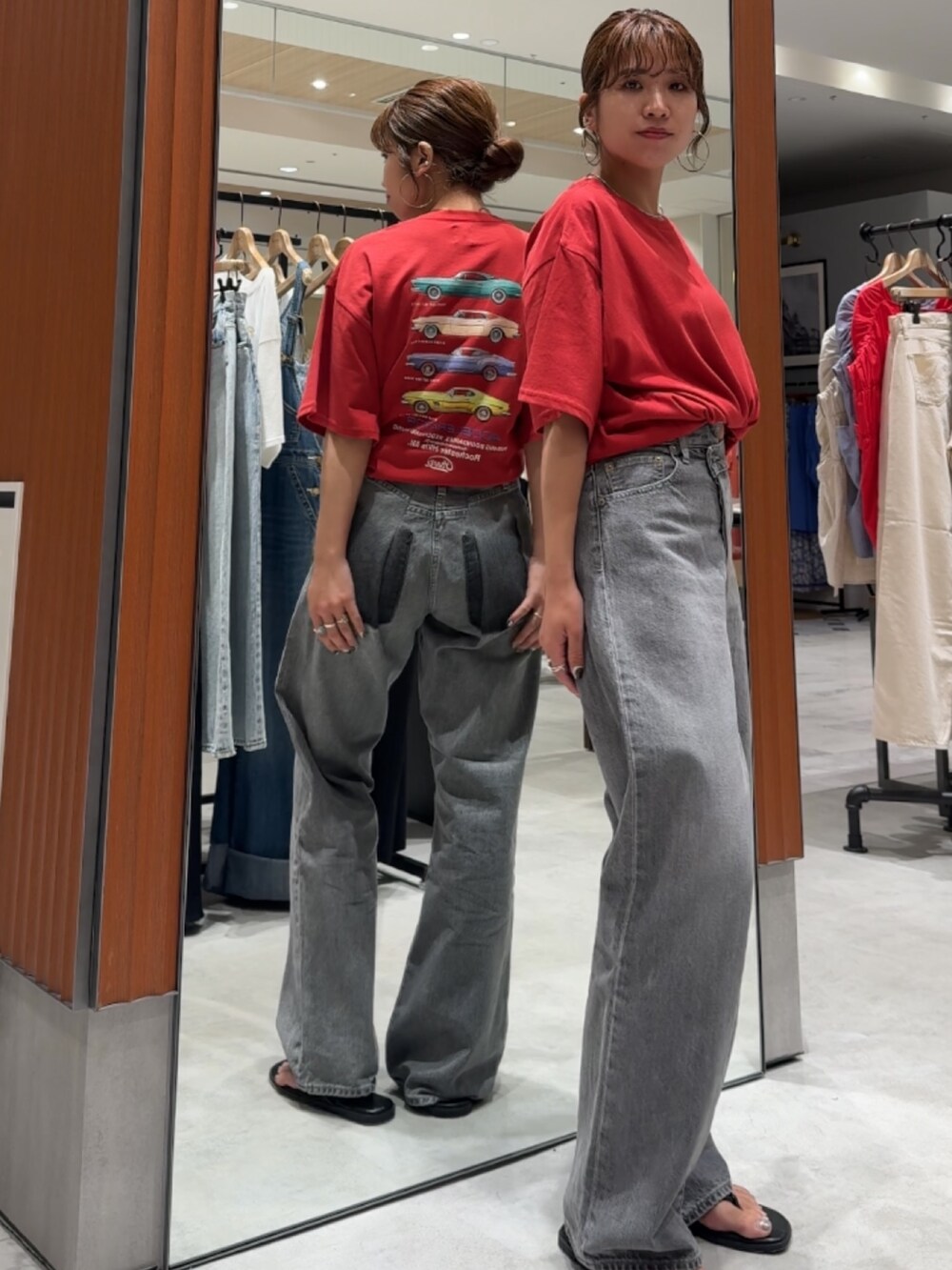 レッド系のTシャツ/カットソー、ブラック系のデニムパンツ、ブラック系のサンダルを着用したレディースの夏コーディネートの4枚目の写真