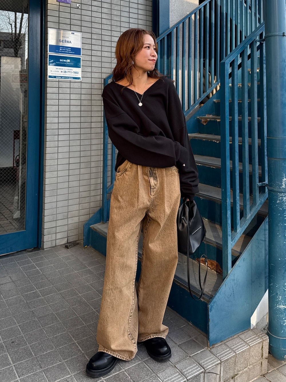 ブラウン系のデニムパンツ、ブラック系のスウェットを着用したレディースの冬コーディネートの7枚目の写真