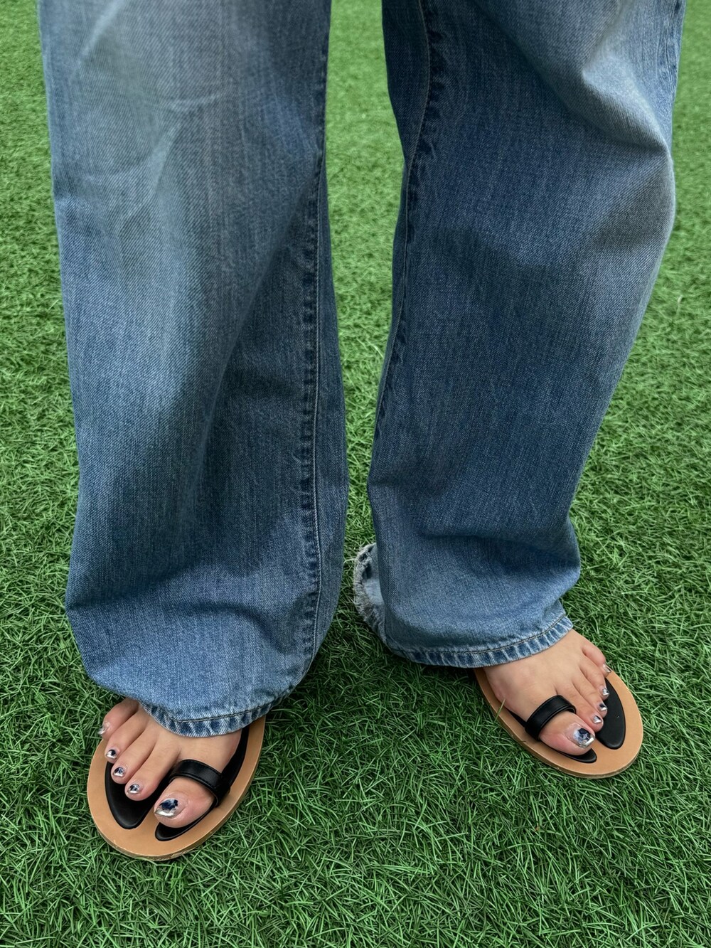 ブラック系のサンダル、ブルー系のデニムパンツ、ブラック系のシャツ/ブラウスを着用したレディースの夏コーディネートの10枚目の写真