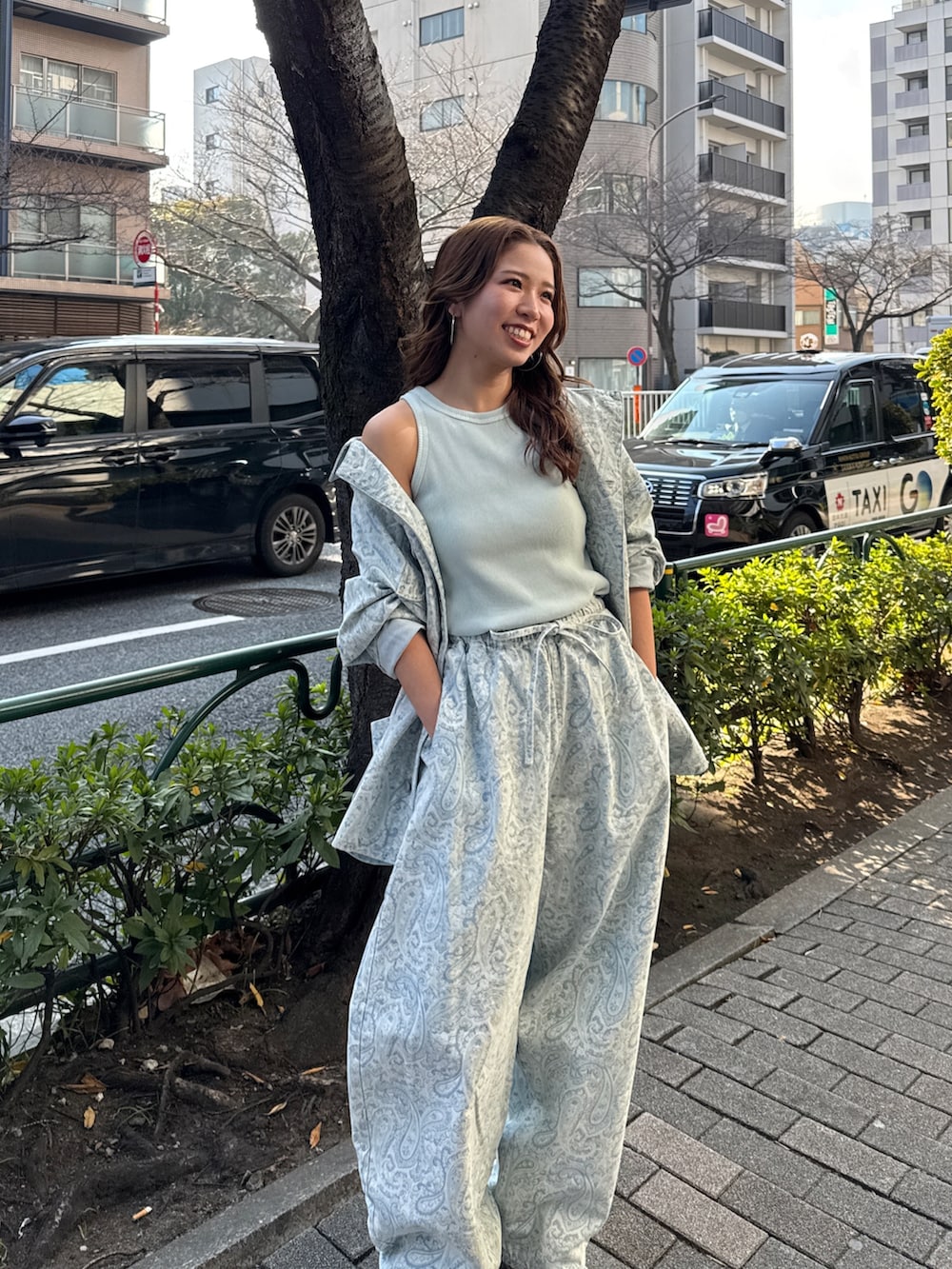 ブルー系のカバーオール、ブルー系のデニムパンツ、ブルー系のタンクトップを着用したレディースの春コーディネートの7枚目の写真