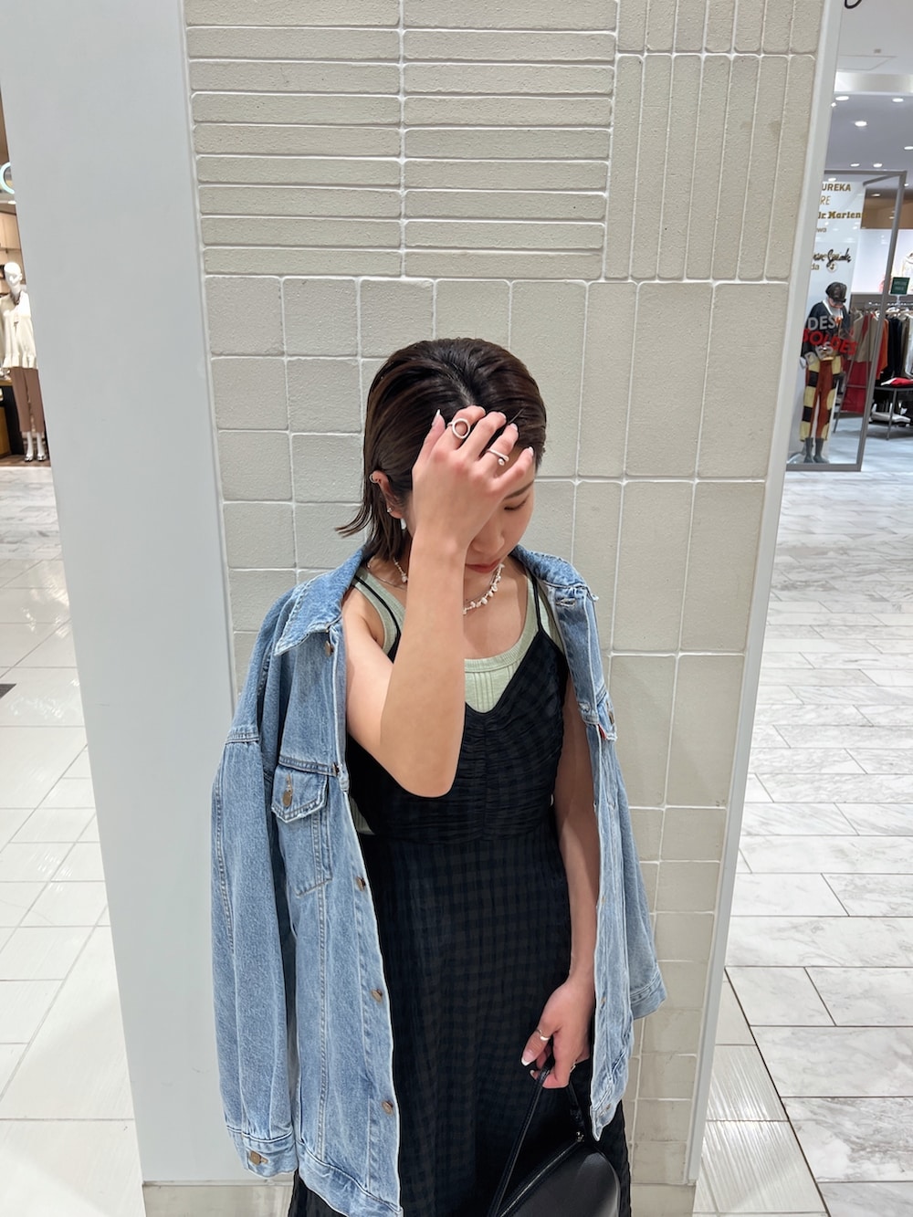 ブラック系のワンピース、グリーン系のタンクトップ、ブルー系のデニムジャケットを着用したレディースの冬コーディネートの9枚目の写真