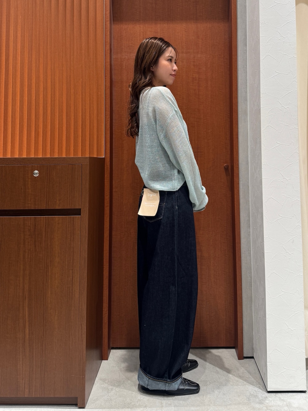 グリーン系のニット/セーター、ブルー系のデニムパンツ、ブラック系のその他シューズを着用したレディースの秋コーディネートの3枚目の写真