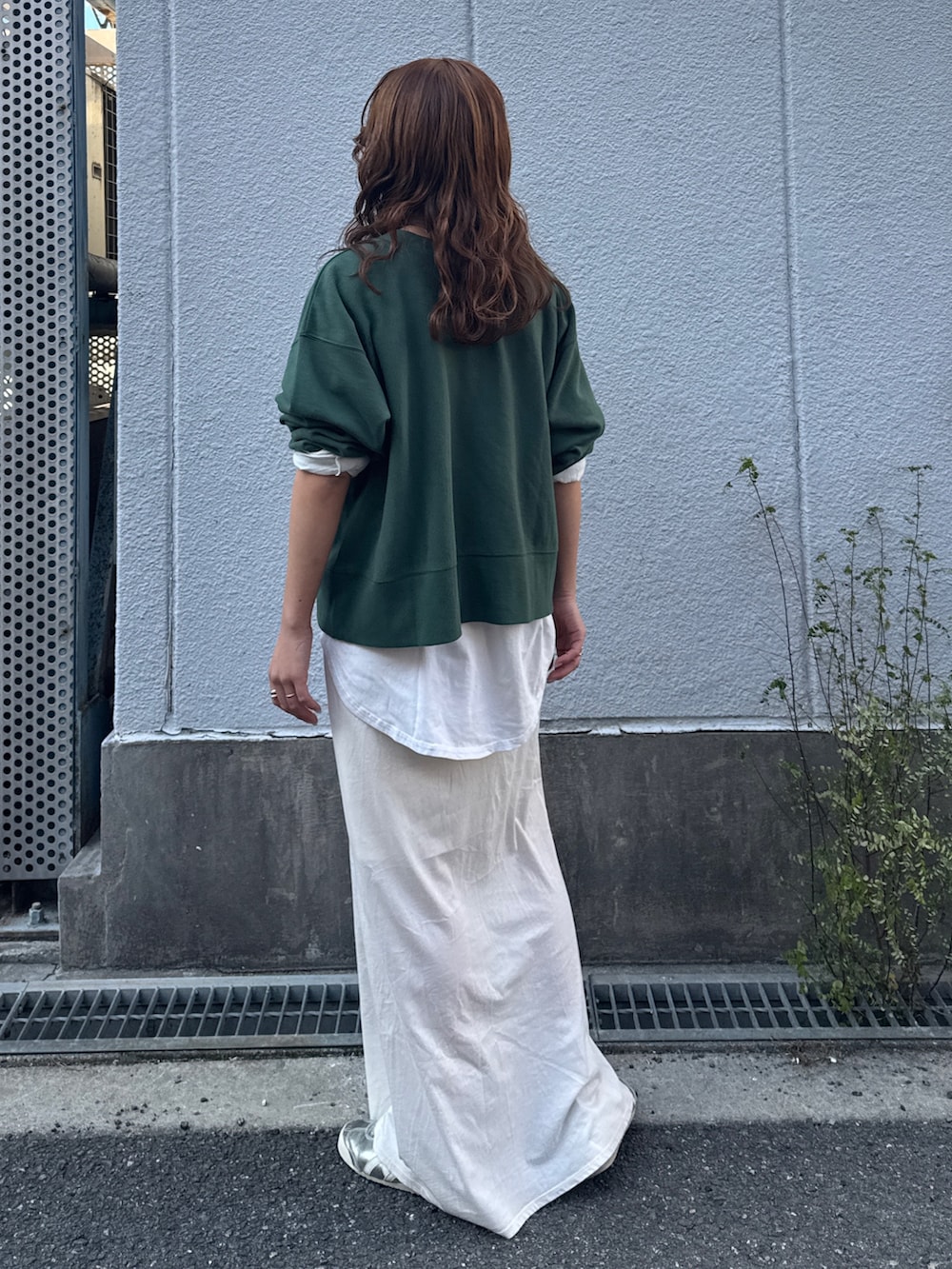 ホワイト系のスカート、ブラウン系のブルゾン、グリーン系のスウェットを着用したレディースの冬コーディネートの7枚目の写真