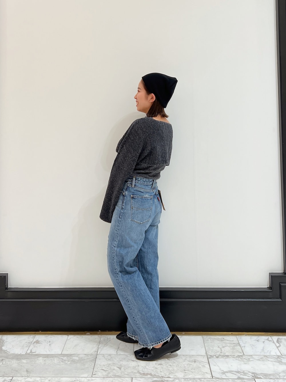 ブルー系のデニムパンツ、グレー系のニット/セーター、ブラック系のパンプスを着用したレディースの春コーディネートの5枚目の写真