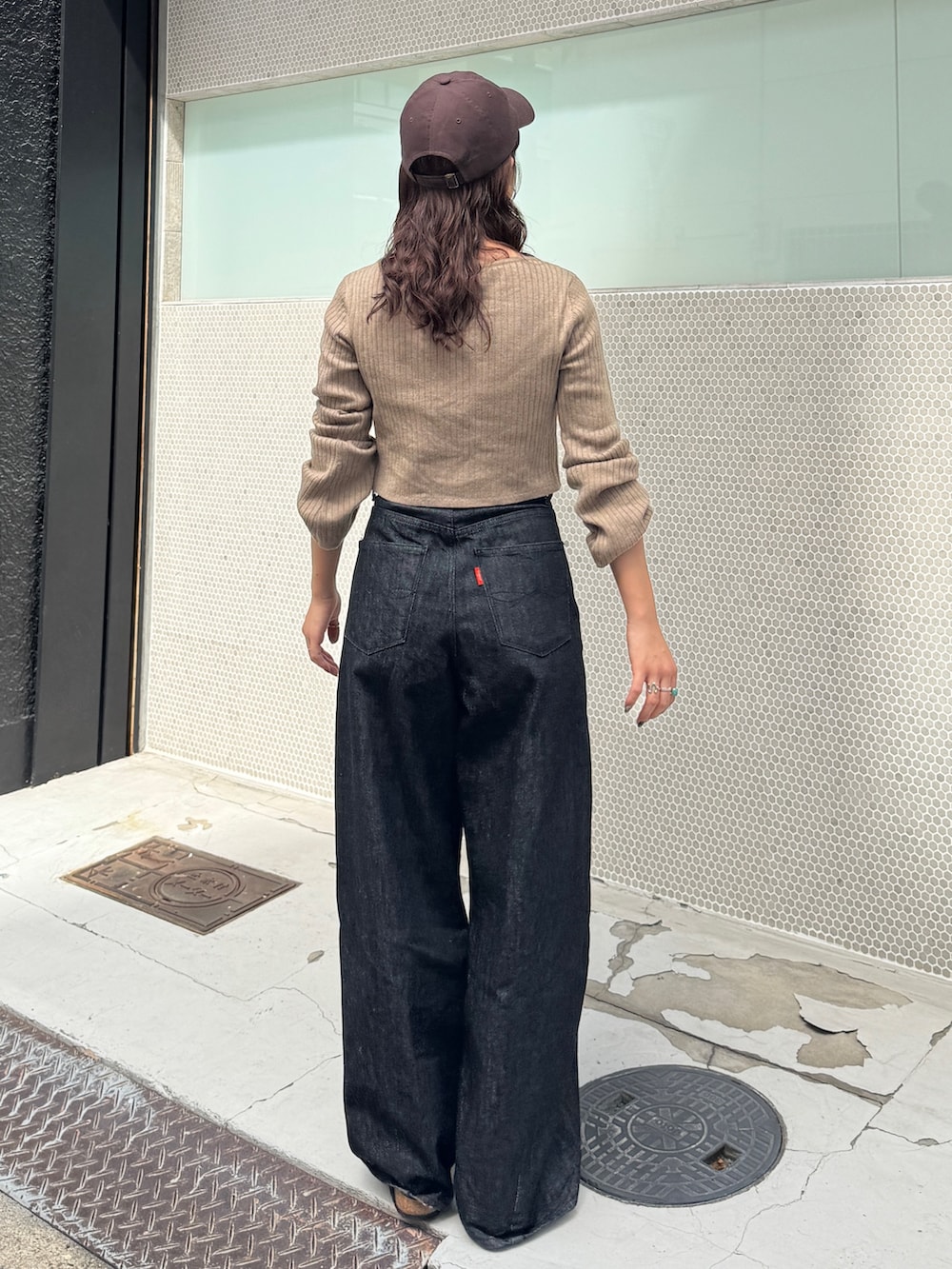 ブラック系のデニムパンツ、グレー系のニット/セーターを着用したレディースの秋コーディネートの5枚目の写真