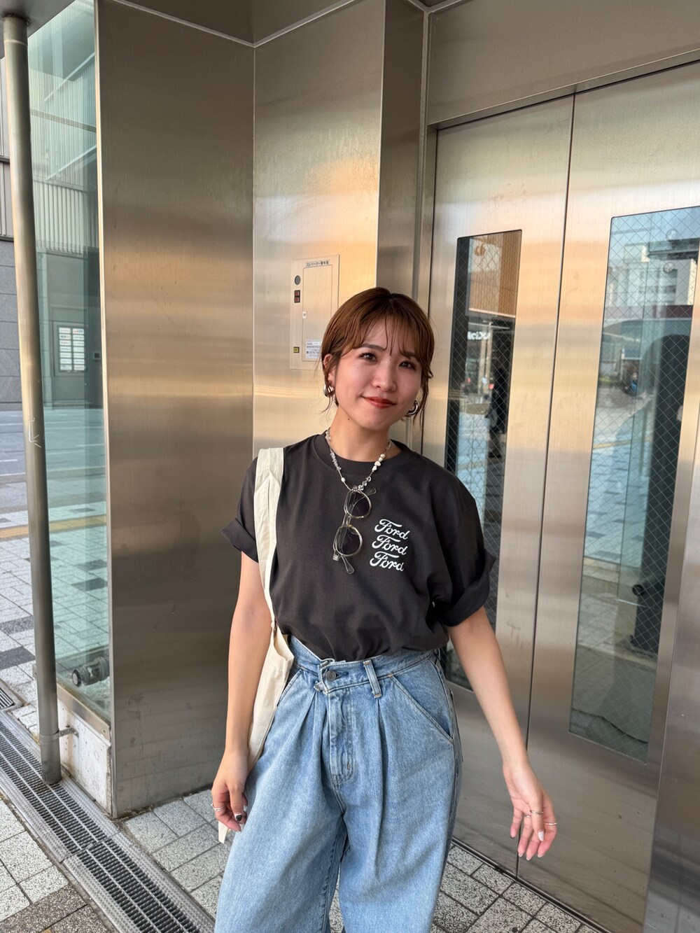 ブルー系のデニムパンツ、グレー系のTシャツ/カットソー、ホワイト系のトートバッグを着用したレディースの夏コーディネートの7枚目の写真