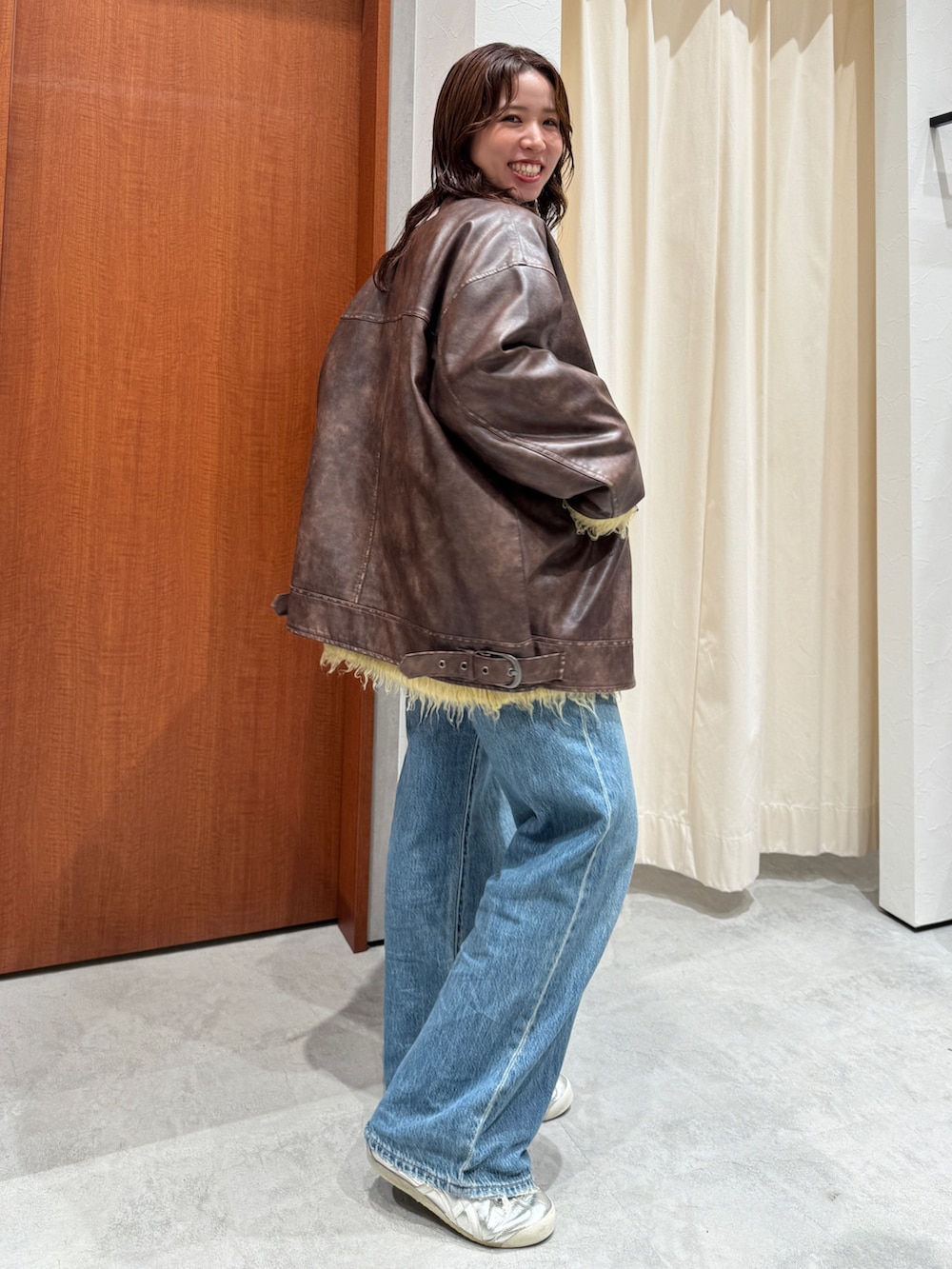 ブルー系のデニムパンツ、イエロー系のカーディガン/ボレロ、ブラウン系のブルゾンを着用したレディースの秋コーディネートの4枚目の写真