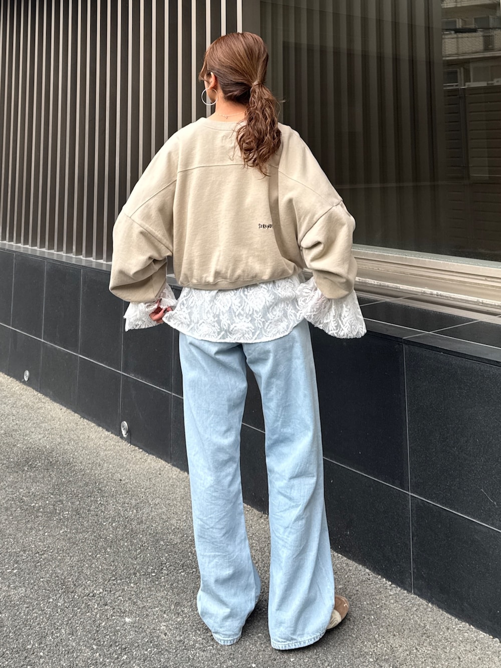 ブルー系のデニムパンツ、ホワイト系のシャツ/ブラウス、ベージュ系のスウェットを着用したレディースの冬コーディネートの3枚目の写真