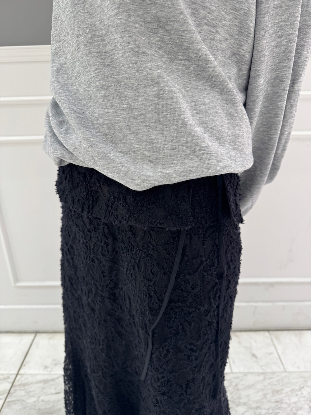 グレー系のTシャツ/カットソー、ブラック系のスカートを着用したレディースの冬コーディネートの9枚目の写真