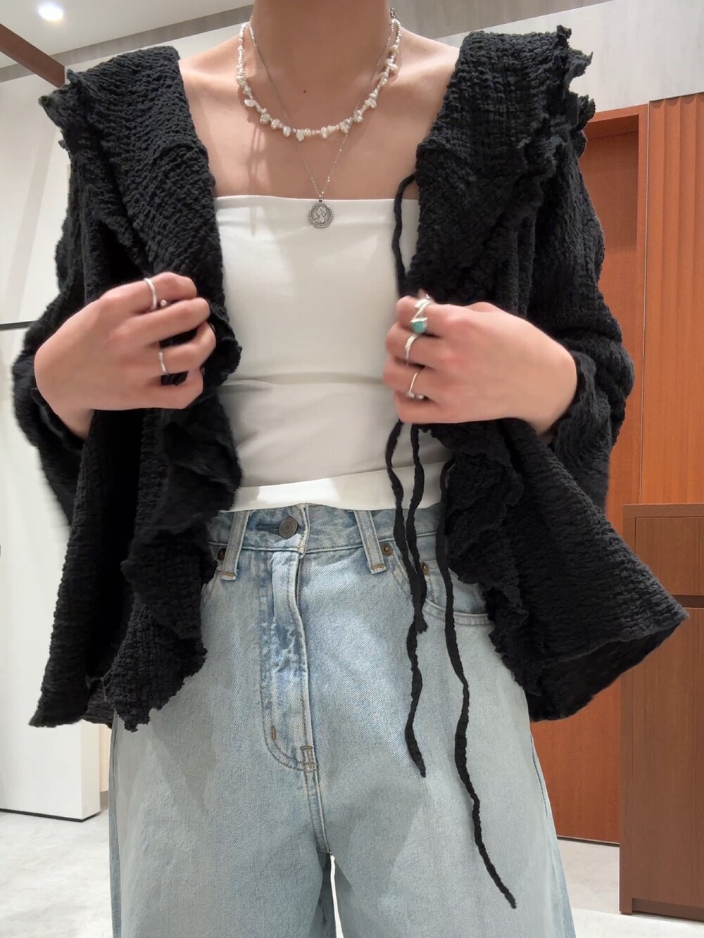 ブラック系のシャツ/ブラウス、ブルー系のデニムパンツを着用したレディースの春コーディネートの10枚目の写真