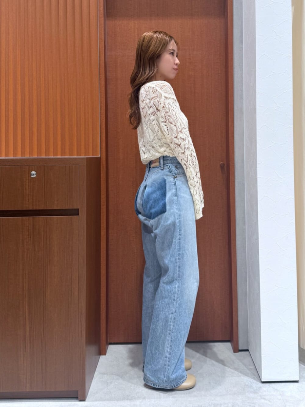 ブルー系のデニムパンツ、ホワイト系のニット/セーターを着用したレディースの夏コーディネートの4枚目の写真