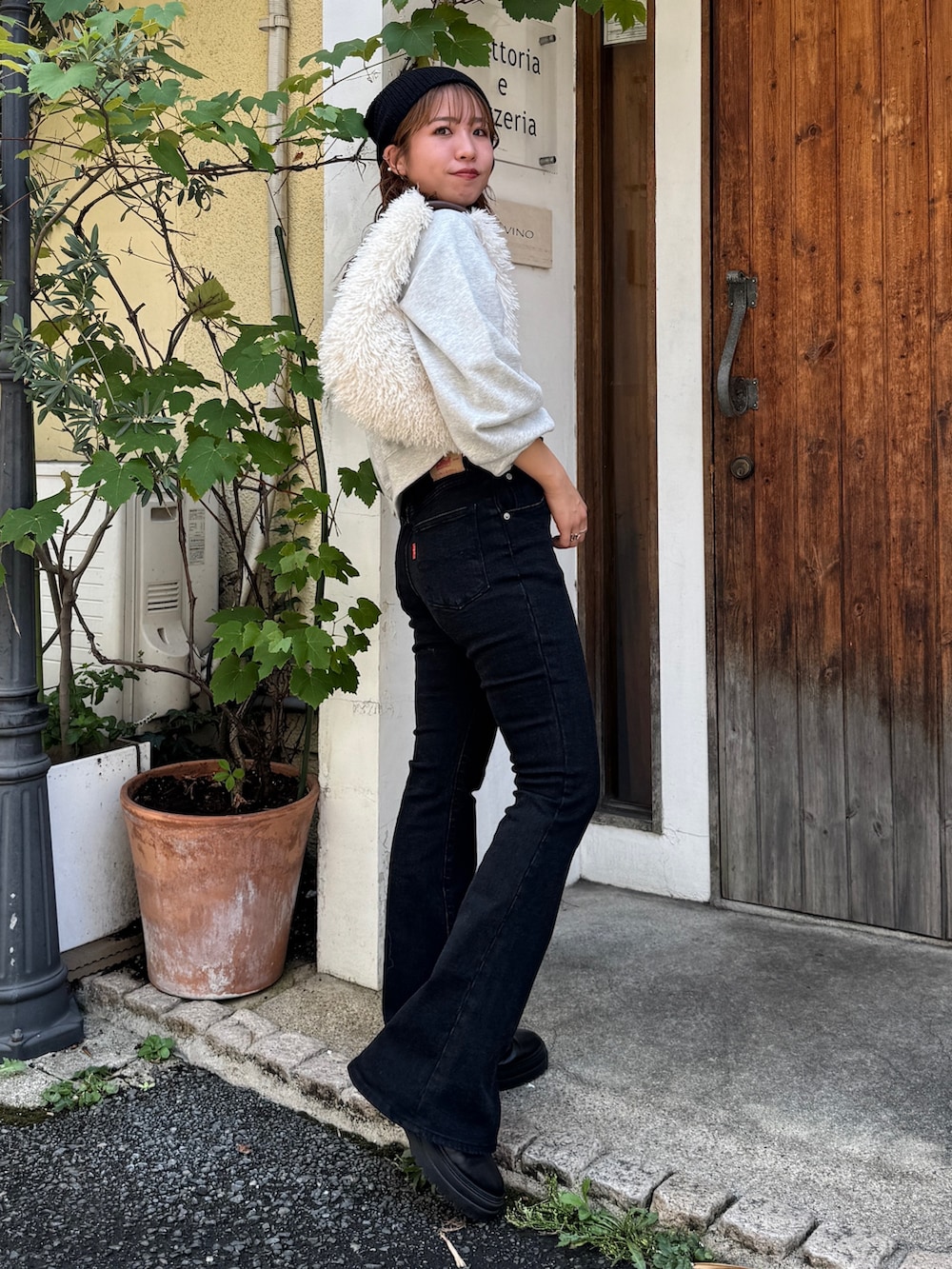 ブラック系のデニムパンツ、グレー系のスウェット、ホワイト系のハンドバッグを着用したレディースの夏コーディネートの3枚目の写真