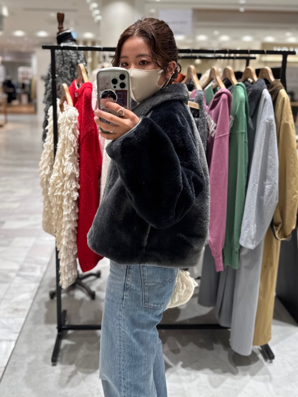 グレー系のブルゾン、グレー系のニット/セーター、ブルー系のデニムパンツを着用したレディースの秋コーディネートの3枚目の写真