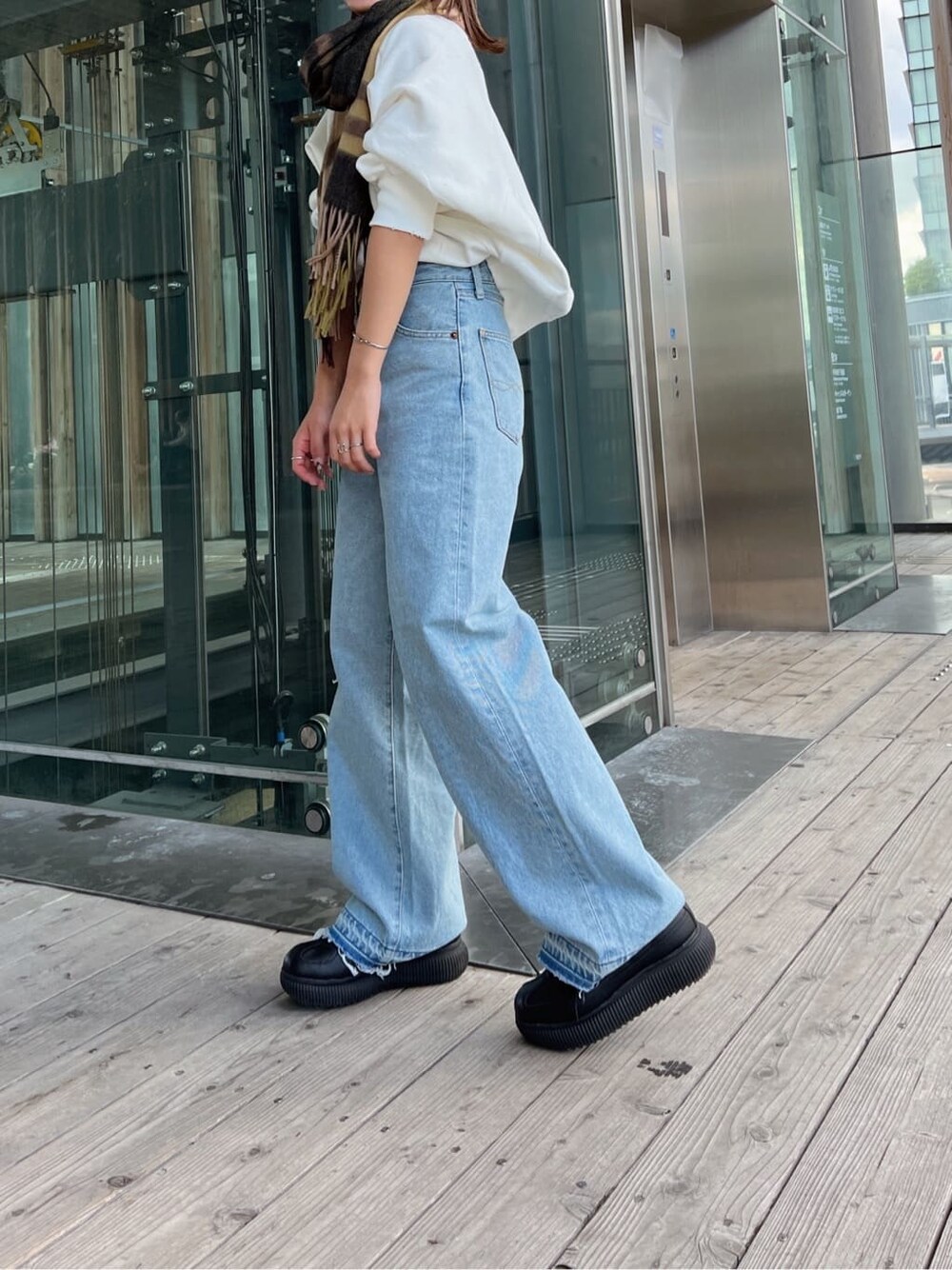 ブルー系のデニムパンツ、ブルー系のデニムパンツ、ホワイト系のスウェットを着用したレディースの秋コーディネートの5枚目の写真