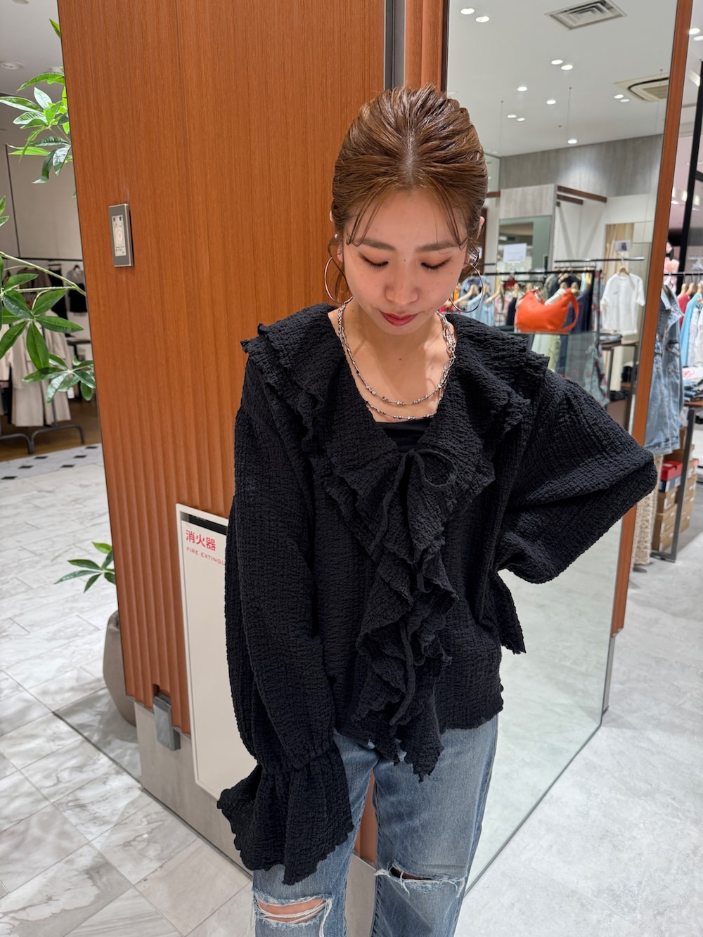 ブルー系のデニムパンツ、ブラック系のシャツ/ブラウス、ホワイト系のパンプスを着用したレディースの春コーディネートの8枚目の写真