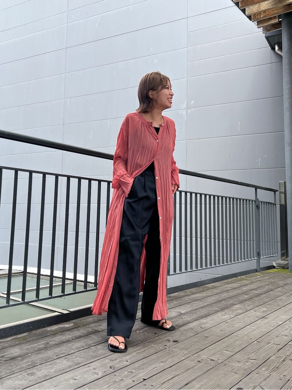 ブラック系のタンクトップ、ピンク系のワンピース、グレー系のスラックスを着用したレディースの夏コーディネートの4枚目の写真