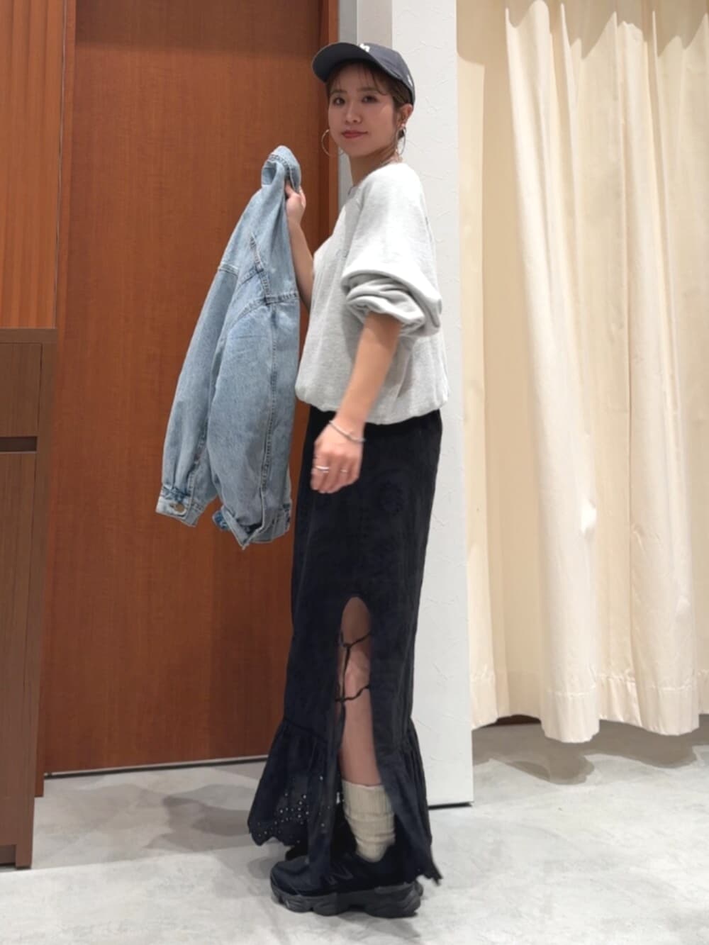 ブラック系のスカート、ブルー系のデニムジャケット、グレー系のスウェットを着用したレディースの春コーディネートの7枚目の写真