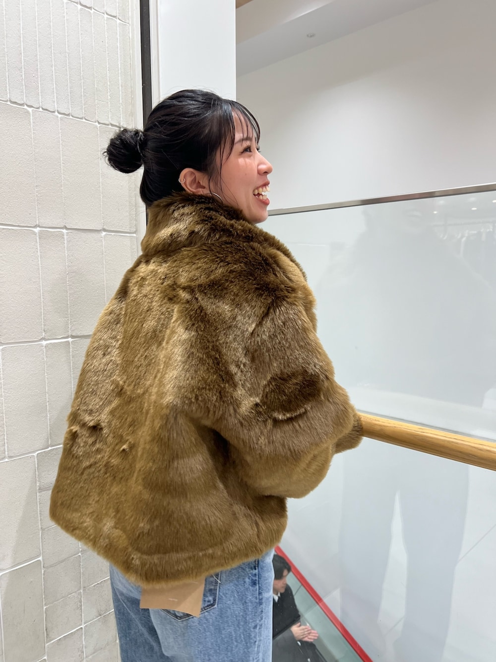 ブルー系のデニムパンツ、ブラウン系のブルゾン、レッド系のニット/セーターを着用したレディースの冬コーディネートの5枚目の写真