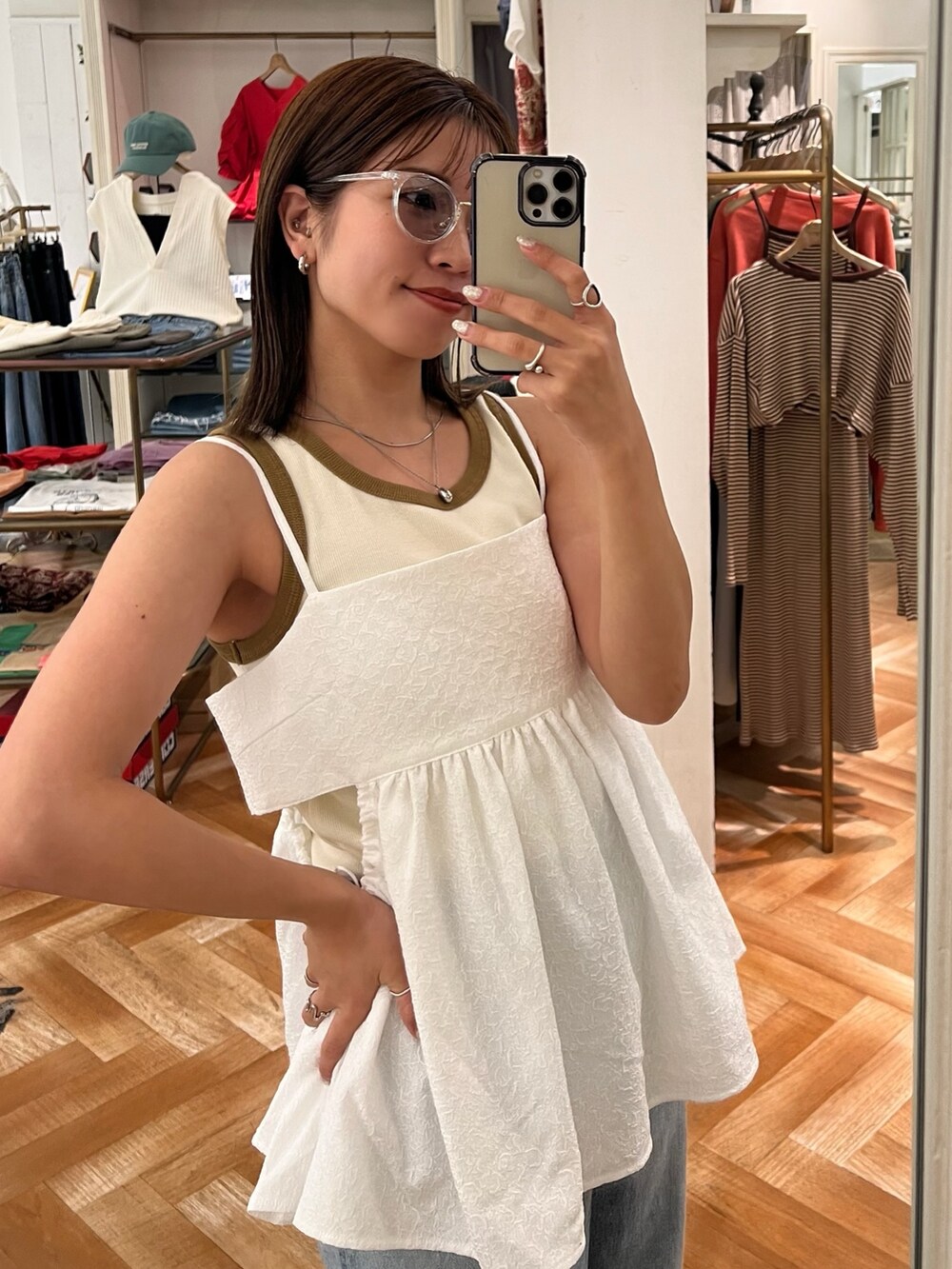 ホワイト系のキャミソール、ブルー系のデニムパンツ、ホワイト系のTシャツ/カットソーを着用したレディースの夏コーディネートの2枚目の写真