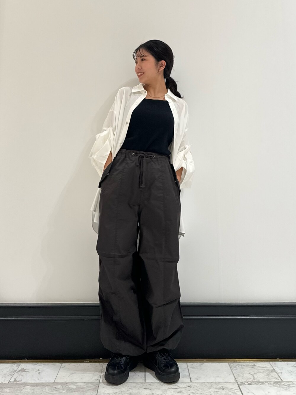 ホワイト系のシャツ/ブラウス、グレー系のその他パンツ、ブラック系のキャミソールを着用したレディースの冬コーディネートの6枚目の写真