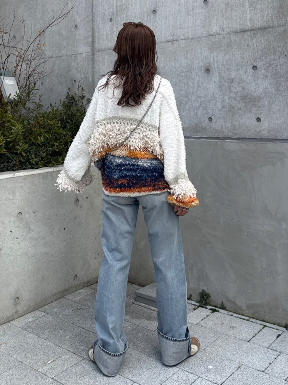 ブルー系のデニムパンツ、ホワイト系のニット/セーター、ブラウン系のスニーカーを着用したレディースの冬コーディネートの4枚目の写真