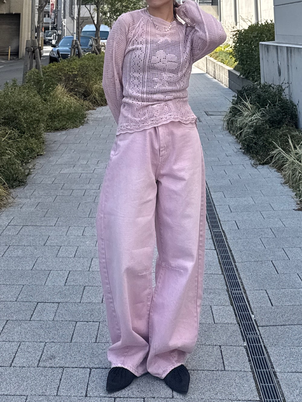 ピンク系のデニムパンツ、ピンク系のニット/セーター、ブラック系のパンプスを着用したレディースの春コーディネートの2枚目の写真