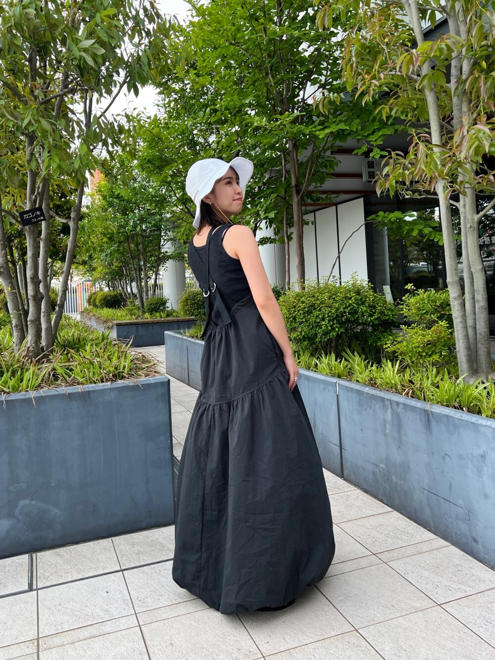 ブラック系のワンピース、グレー系のタンクトップ、ブラック系のサンダルを着用したレディースの春コーディネートの6枚目の写真