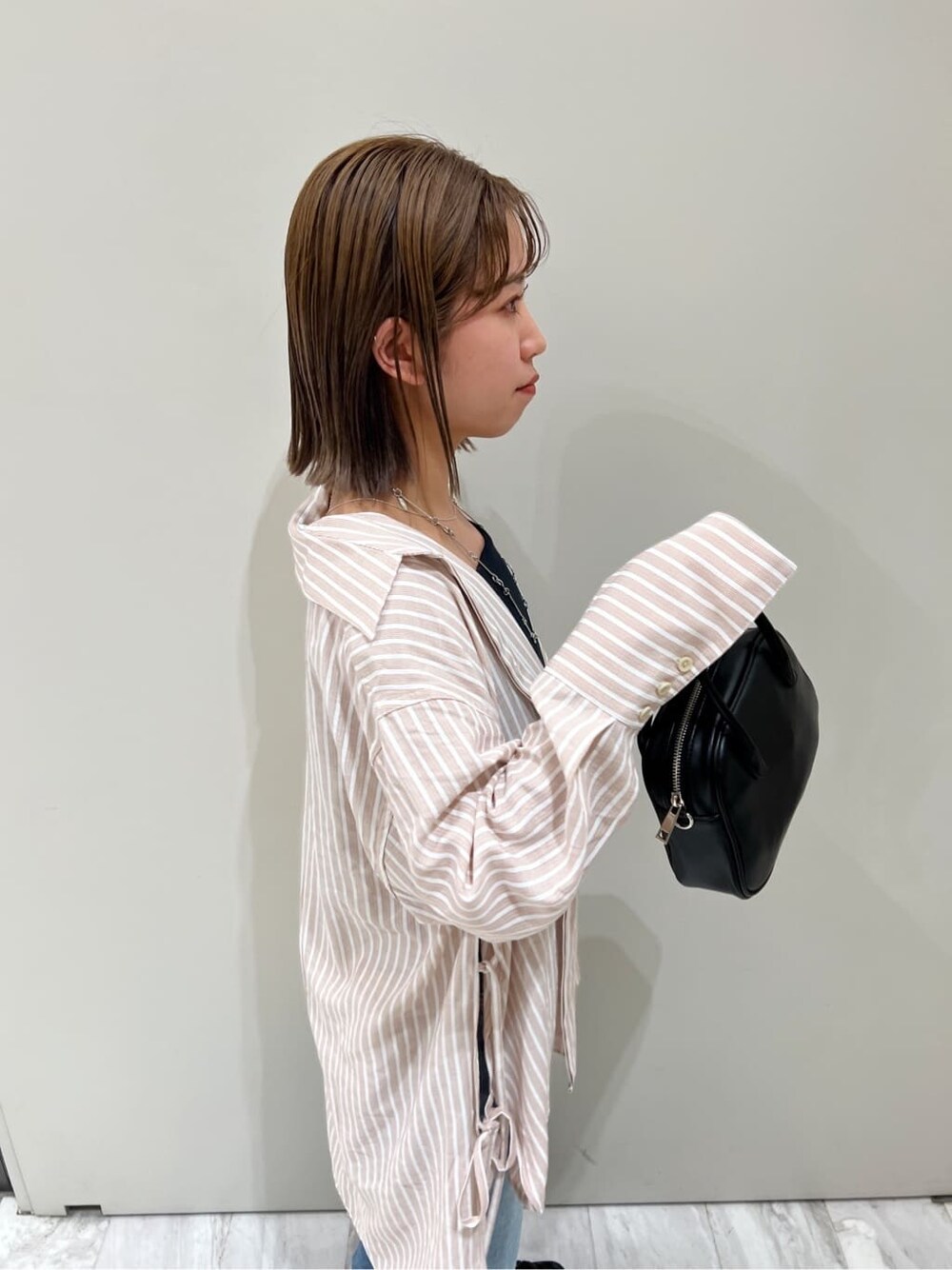 ブラック系のサンダル、ピンク系のシャツ/ブラウス、ブラック系のハンドバッグを着用したレディースの春コーディネートの8枚目の写真