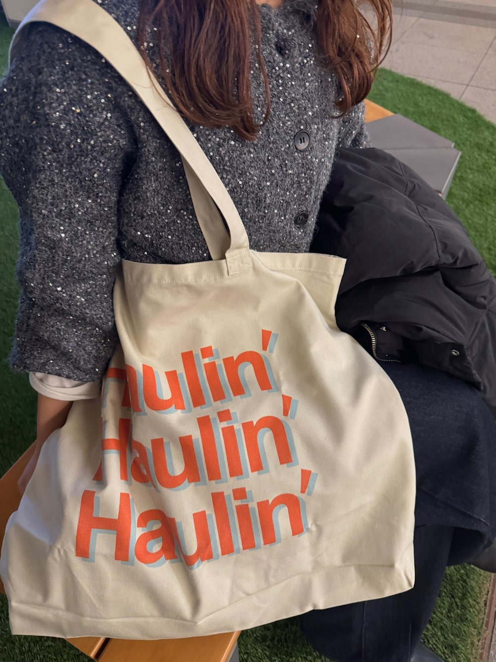 グレー系のカーディガン/ボレロ、ブラック系のダウンジャケット/コート、ホワイト系のトートバッグを着用したレディースの冬コーディネートの9枚目の写真