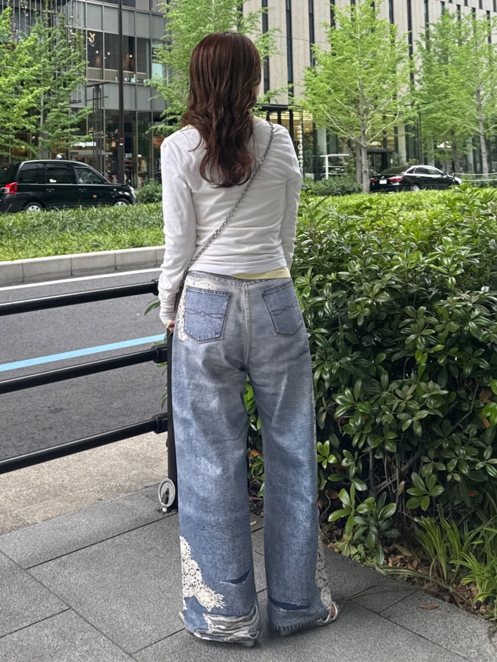 ホワイト系のTシャツ/カットソー、イエロー系のTシャツ/カットソー、ブルー系のデニムパンツを着用したレディースの春コーディネートの3枚目の写真