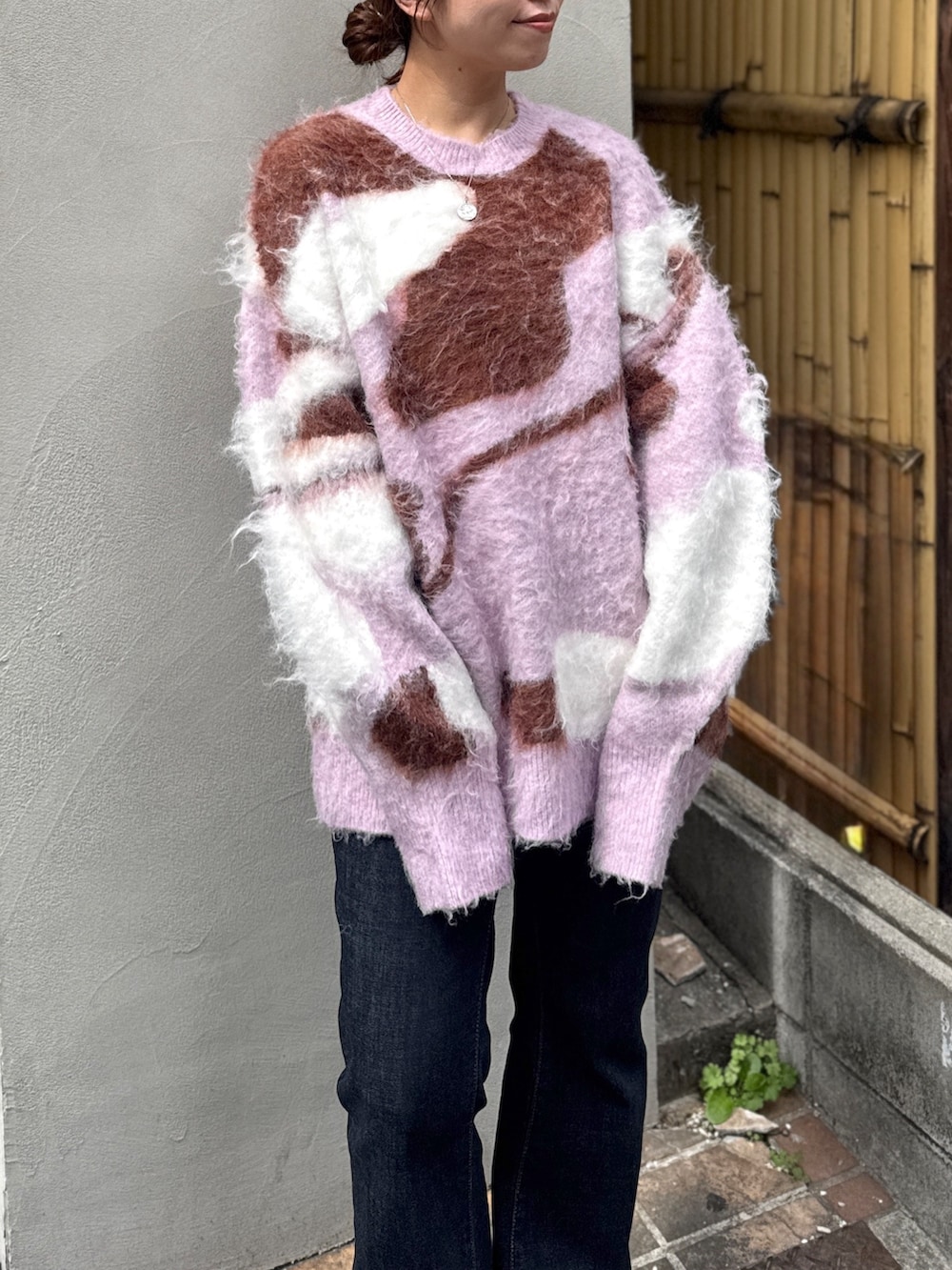 ブルー系のデニムパンツ、ブラウン系のブーツ、ピンク系のニット/セーターを着用したレディースの秋コーディネートの8枚目の写真