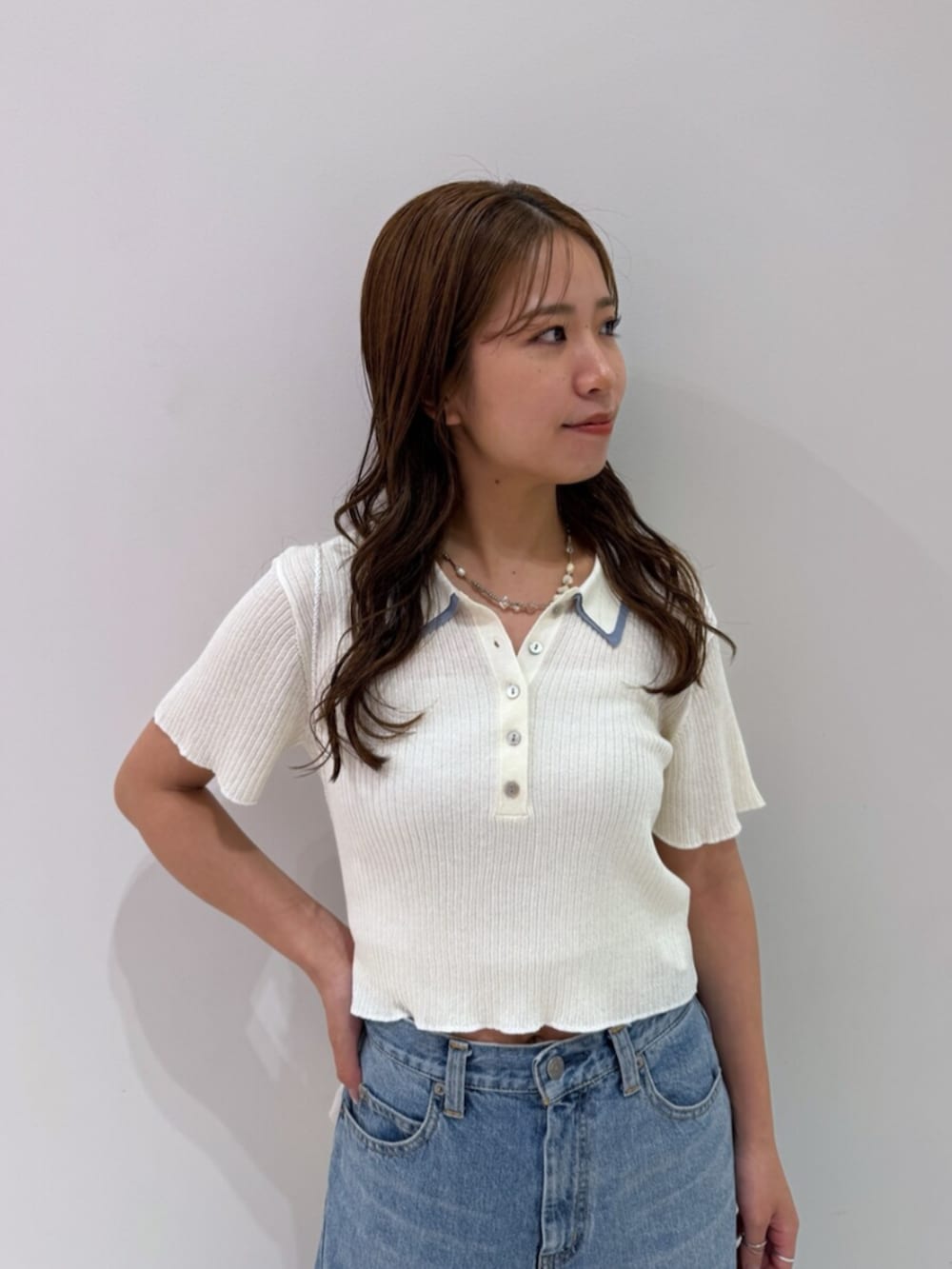 その他のサンダル、ホワイト系のハンドバッグ、ブルー系のデニムパンツを着用したレディースの夏コーディネートの8枚目の写真