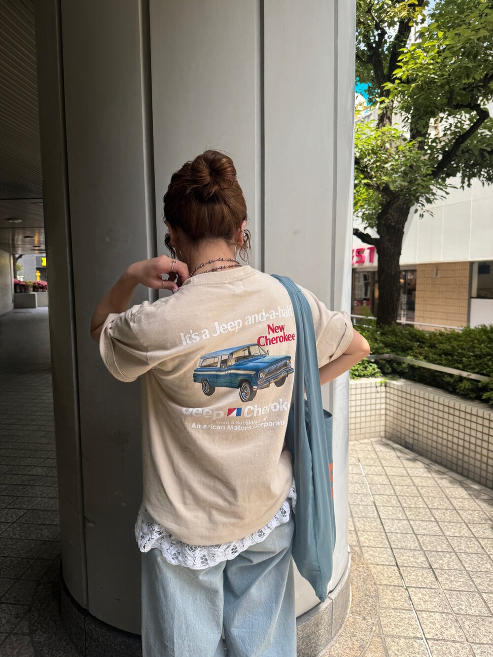 ブルー系のデニムパンツ、ブルー系のトートバッグ、ホワイト系のシャツ/ブラウスを着用したレディースの夏コーディネートの9枚目の写真