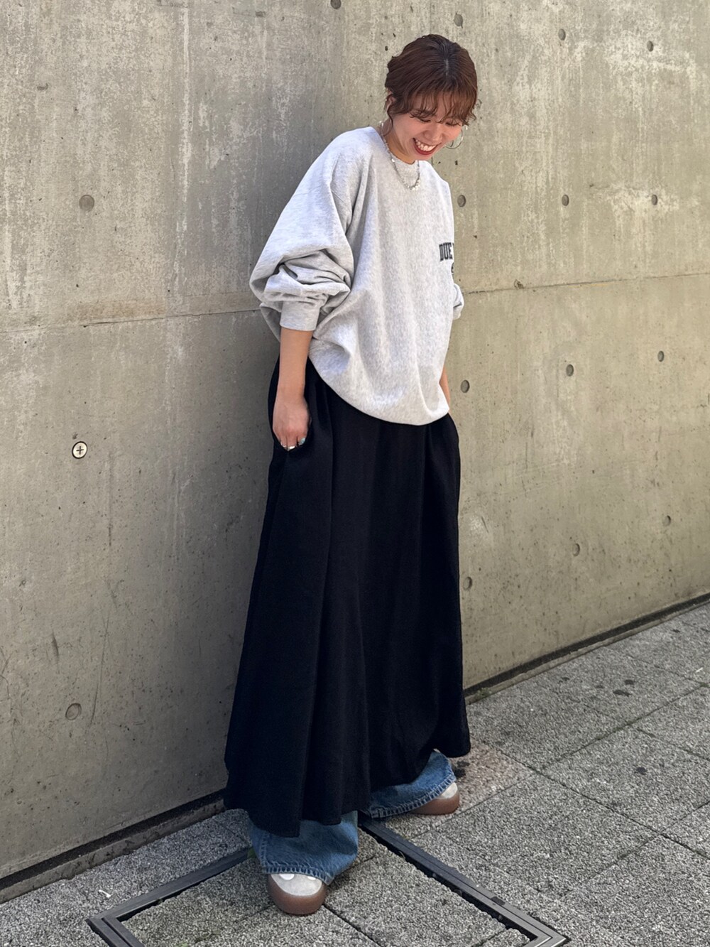 ブルー系のデニムパンツ、ブラック系のワンピース、グレー系のスウェットを着用したレディースの夏コーディネートの2枚目の写真