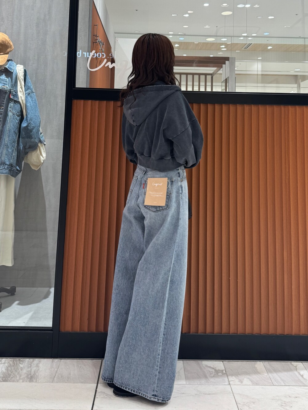 ブルー系のデニムパンツ、グレー系のパーカー、ブラック系のスリッポンを着用したレディースの秋コーディネートの3枚目の写真