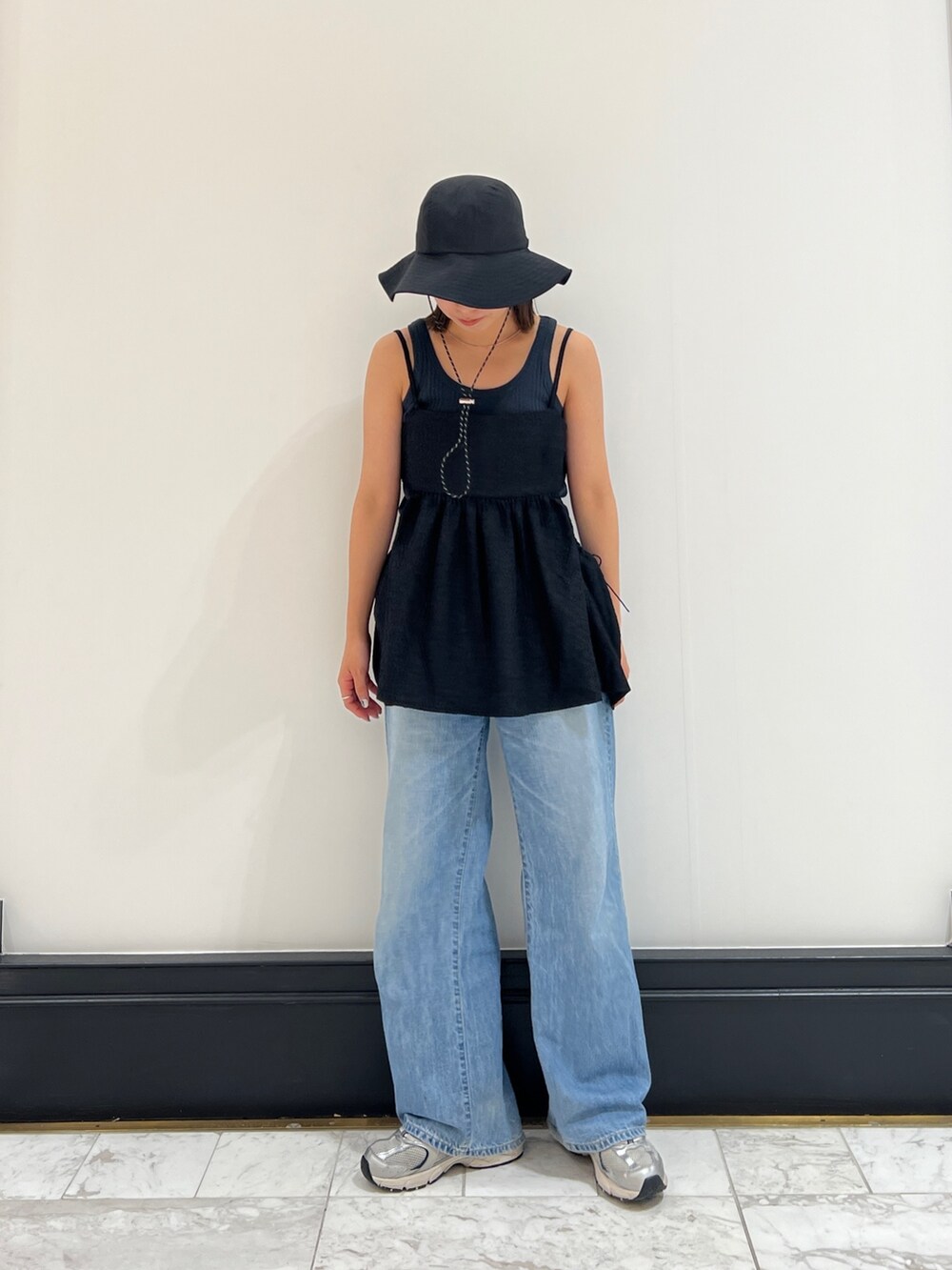 グレー系のタンクトップ、ブルー系のデニムパンツ、ブラック系のシャツ/ブラウスを着用したレディースの春コーディネートの5枚目の写真