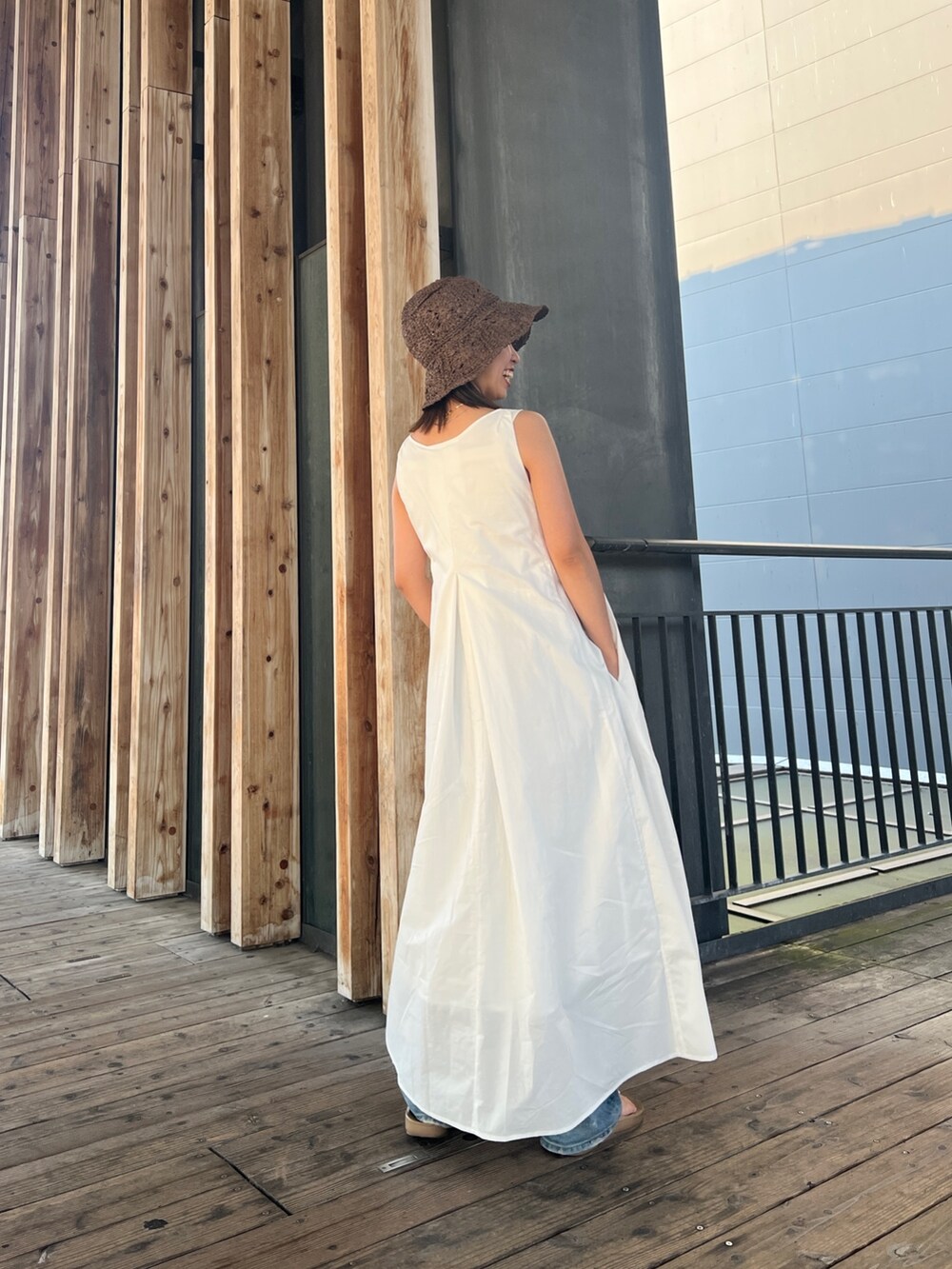 ホワイト系のワンピース、ブルー系のデニムパンツ、ブラウン系のハットを着用したレディースの夏コーディネートの3枚目の写真