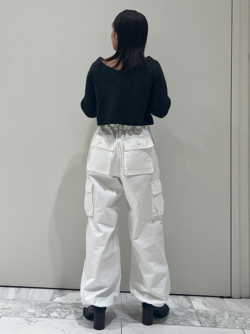 ブラック系のブーツ、ホワイト系のカーゴパンツ、グレー系のニット/セーターを着用したレディースの秋コーディネートの7枚目の写真