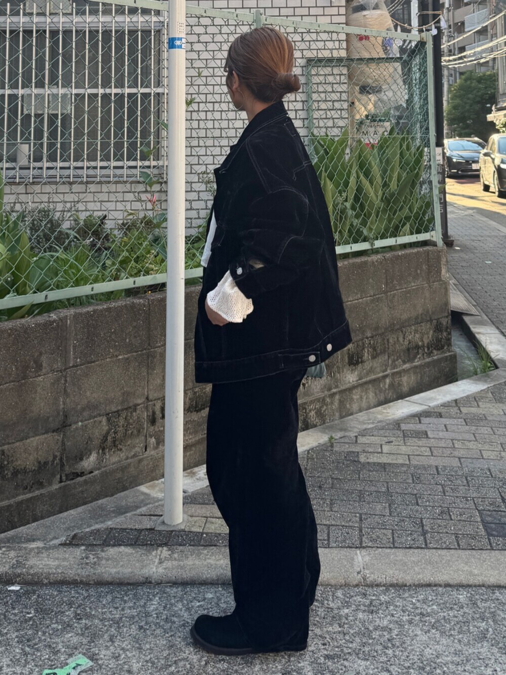 ブラック系のスリッポン、ブラック系のデニムパンツ、ブルー系のトートバッグを着用したレディースの夏コーディネートの5枚目の写真