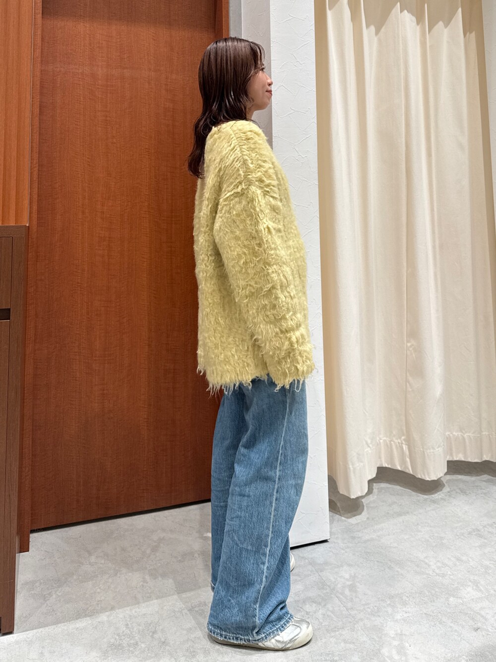 ブルー系のデニムパンツ、イエロー系のカーディガン/ボレロを着用したレディースの秋コーディネートの3枚目の写真