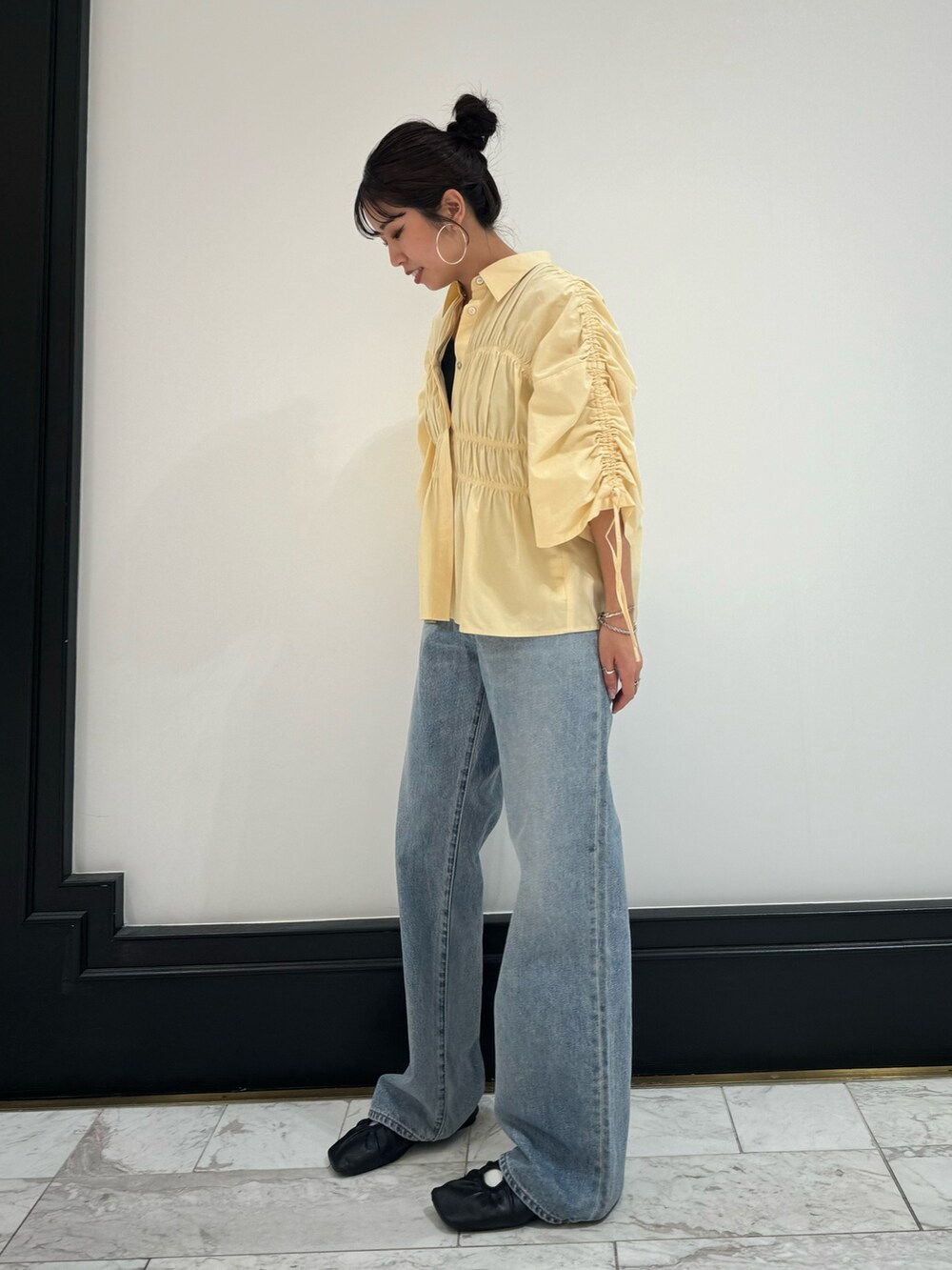 イエロー系のシャツ/ブラウス、ブルー系のデニムパンツ、グレー系のTシャツ/カットソーを着用したレディースの春コーディネートの3枚目の写真