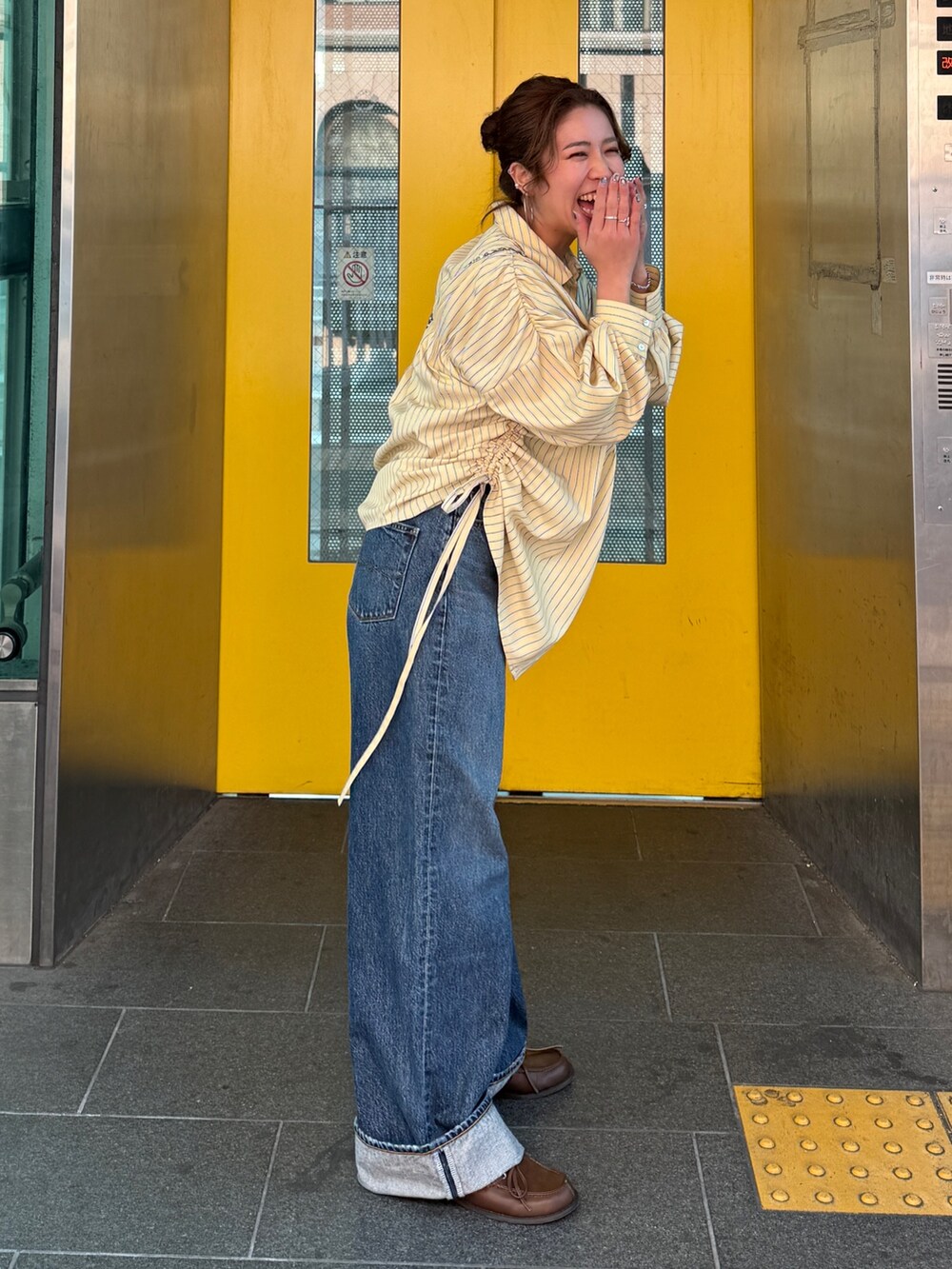 イエロー系のシャツ/ブラウス、ブルー系のデニムパンツ、ブラウン系のローファーを着用したレディースの冬コーディネートの3枚目の写真