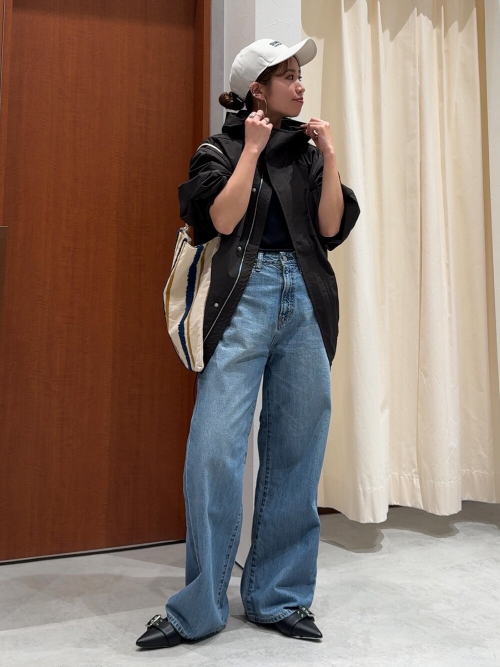 ブラック系のブルゾン、ブラック系のTシャツ/カットソー、ブルー系のデニムパンツを着用したレディースの春コーディネートの2枚目の写真