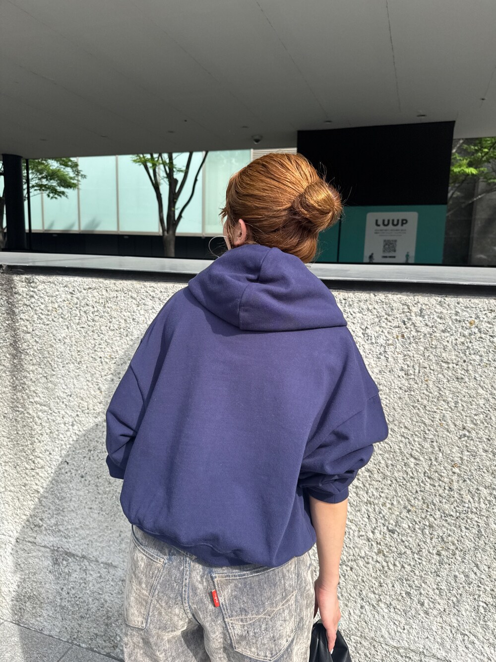 ベージュ系のデニムパンツ、ブルー系のパーカーを着用したレディースの夏コーディネートの9枚目の写真