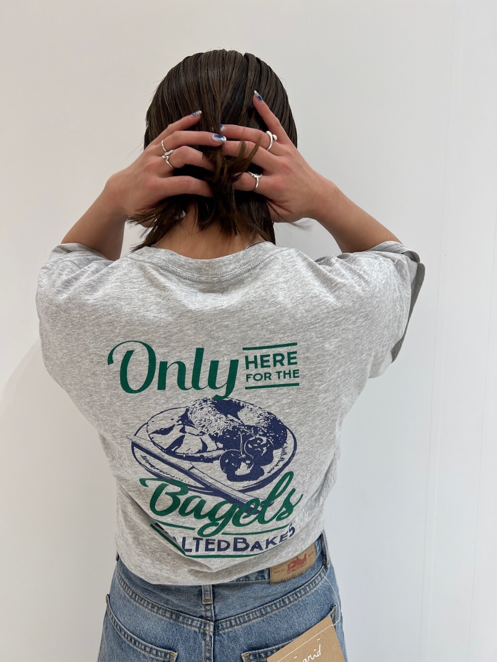 ブルー系のデニムパンツ、グレー系のTシャツ/カットソー、ホワイト系のスニーカーを着用したレディースの春コーディネートの6枚目の写真