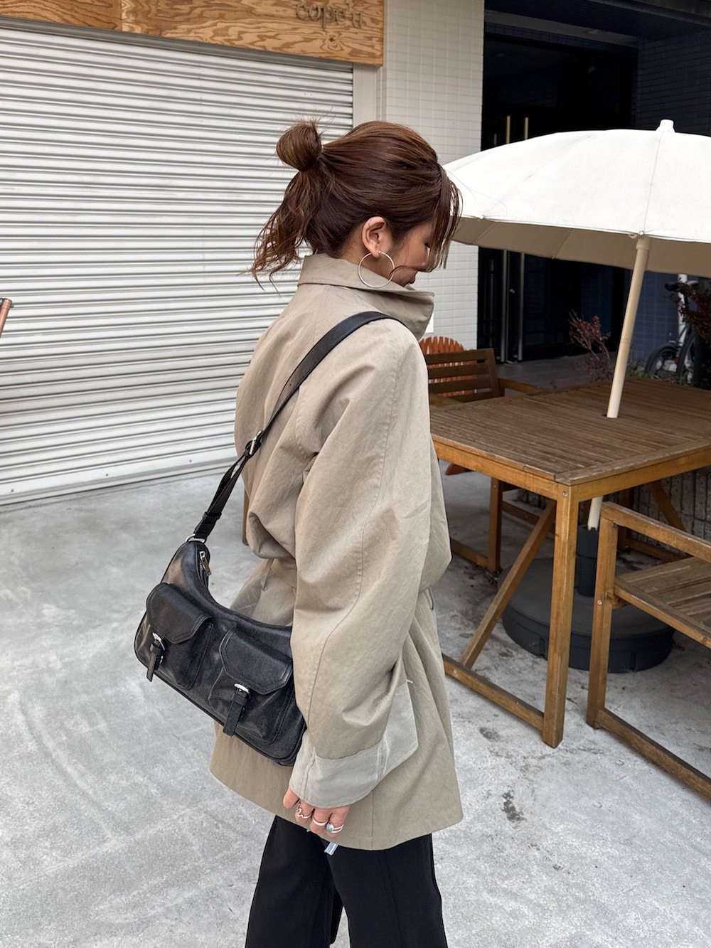 グリーン系のトレンチコート、ブラック系のその他パンツを着用したレディースの冬コーディネートの7枚目の写真