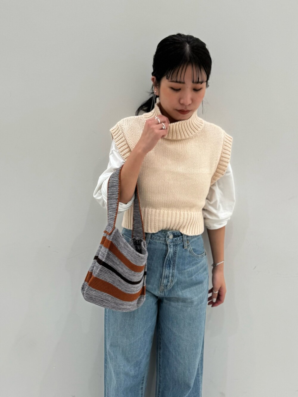 ホワイト系のワンピース、ホワイト系のTシャツ/カットソー、グレー系のハンドバッグを着用したレディースの冬コーディネートの3枚目の写真