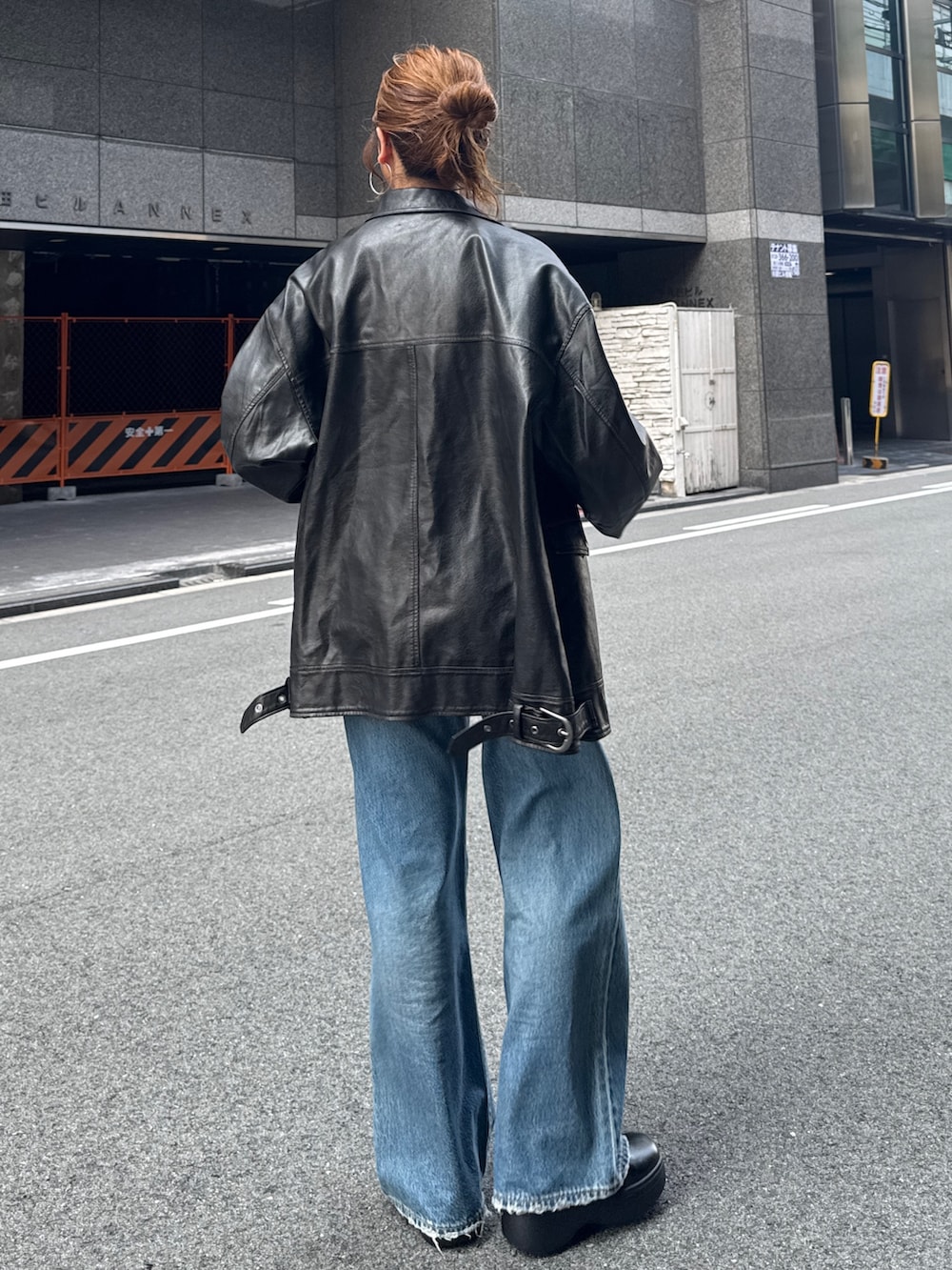 ブラック系のブルゾン、ブルー系のデニムパンツを着用したレディースの秋コーディネートの6枚目の写真